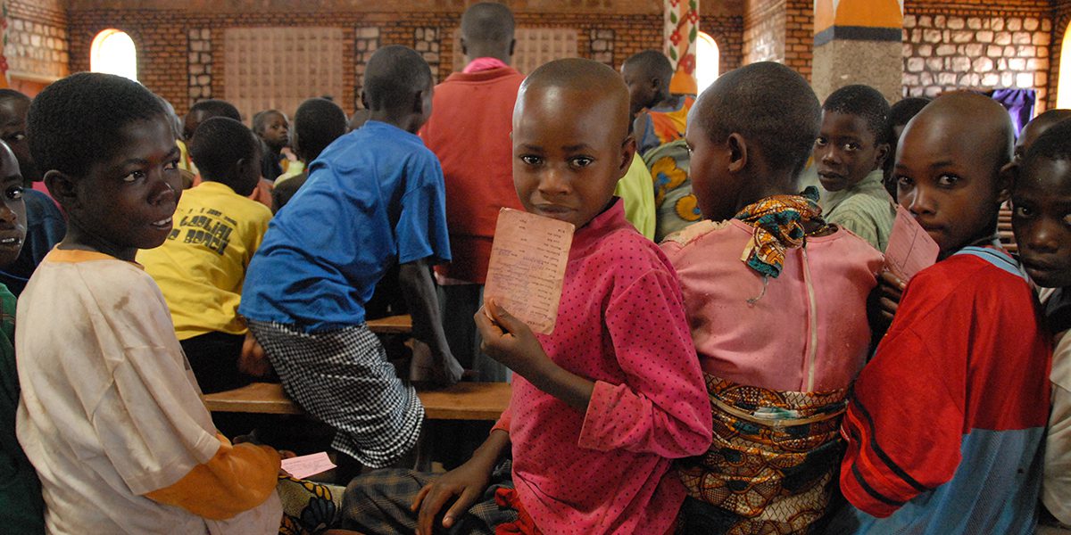 Jóvenes preparándose para la Primera Comunión en la Parroquia de Cristo, Luz del Mundo, en Giteranyi sonríen mientras esperan que comience su clase de catequesis. Servicio Jesuita Refugiados Burundi
