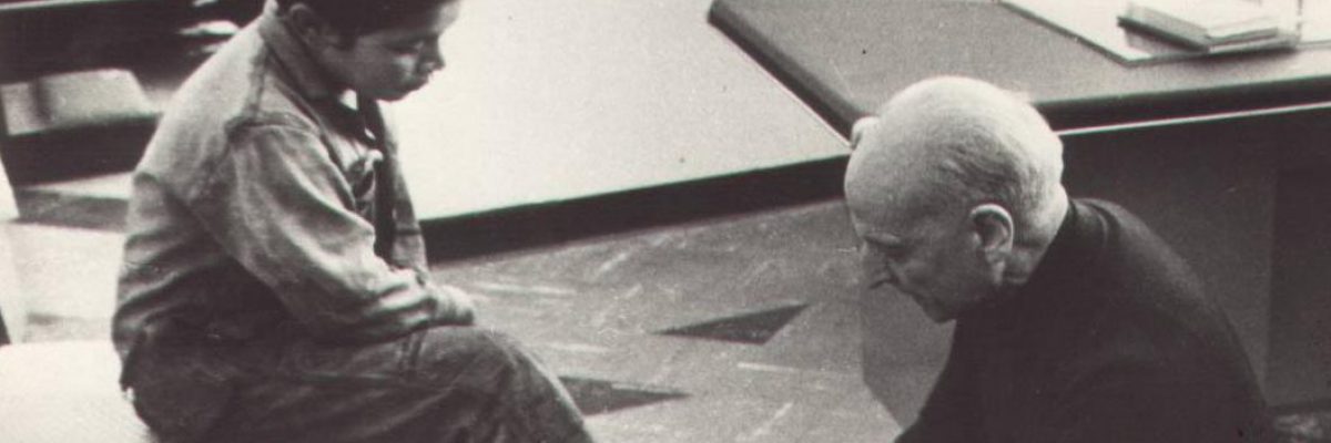 Fr Pedro Arrupe SJ shining shoes for a children in Quito, Ecuador in 1971.