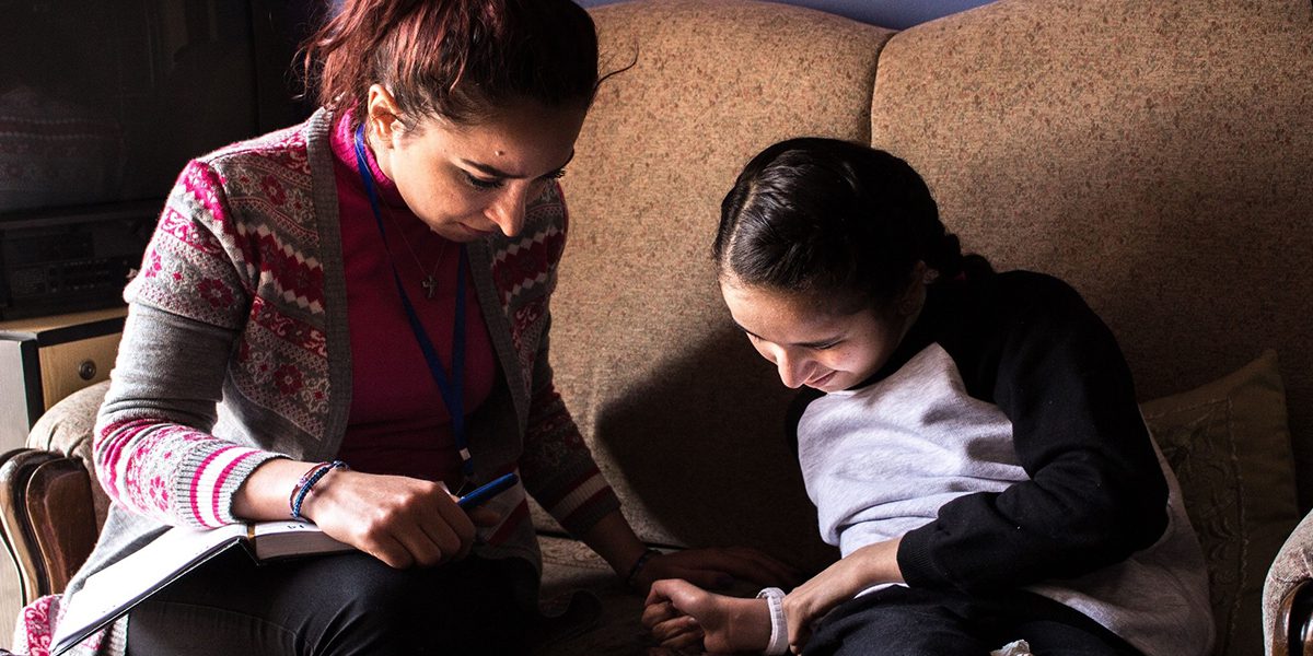 Un miembro del equipo del JRS Siria visita a Amina, una niña siria que aprendió de forma autodidacta a leer y escribir después de haber sido desplazada por el conflicto.