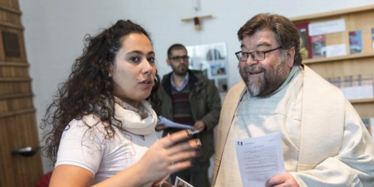 A refugee from Syria speaks with Fr Frido Pflüger SJ, former JRS Germany Country Director, about a community event she's helping to organise.
