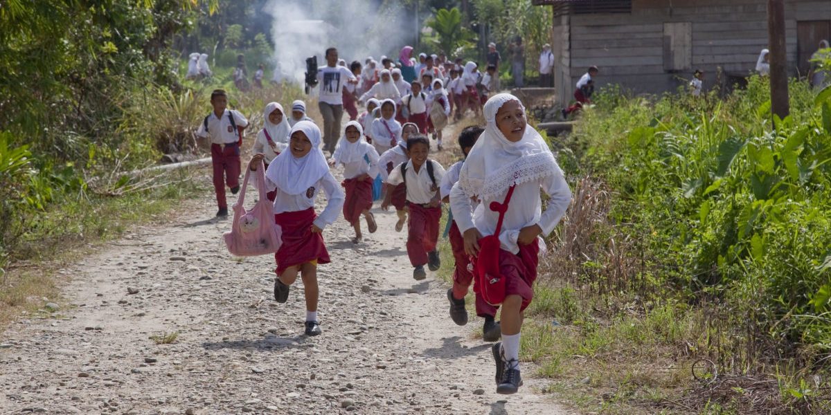 Niñas y niños corren durante el simulacro de una evacuación de emergencia organizada por el equipo de Preparación para Desastres del JRS en la aldea de Lawe Sawah.