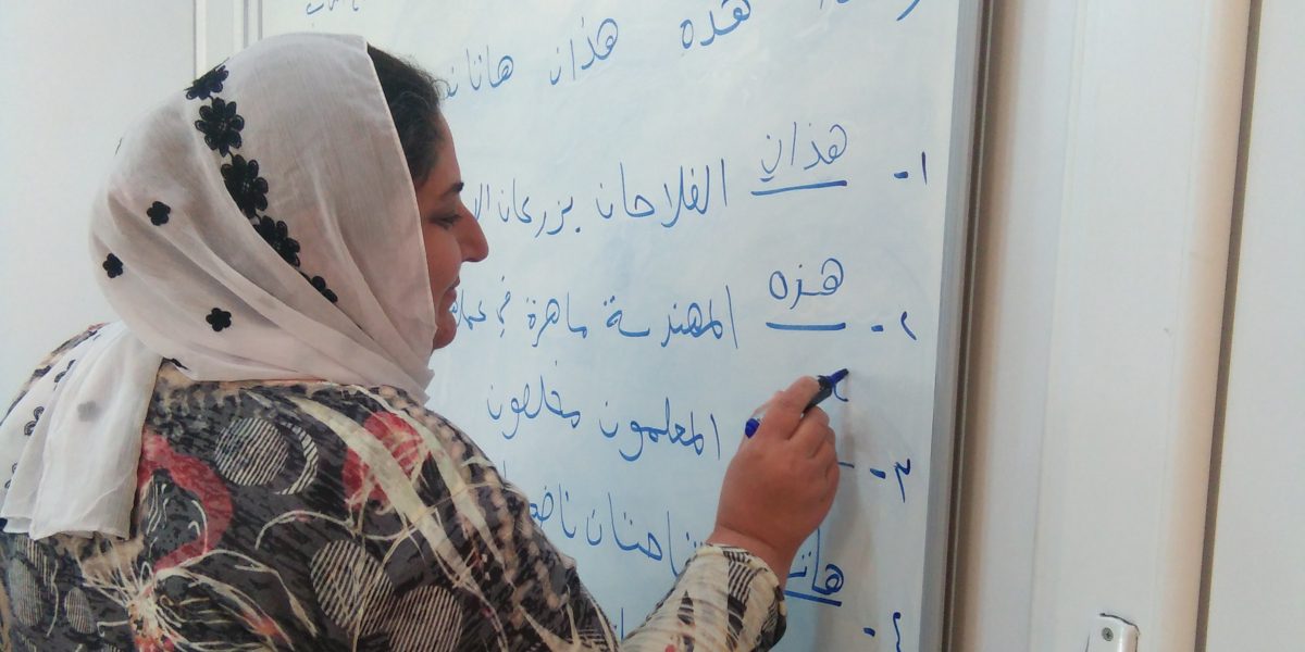 Una mujer practica su escritura en un curso de alfabetización ofrecido por el JRS en el campamento de Sharya, en Irak.(Servicio Jesuita de Refugiados)