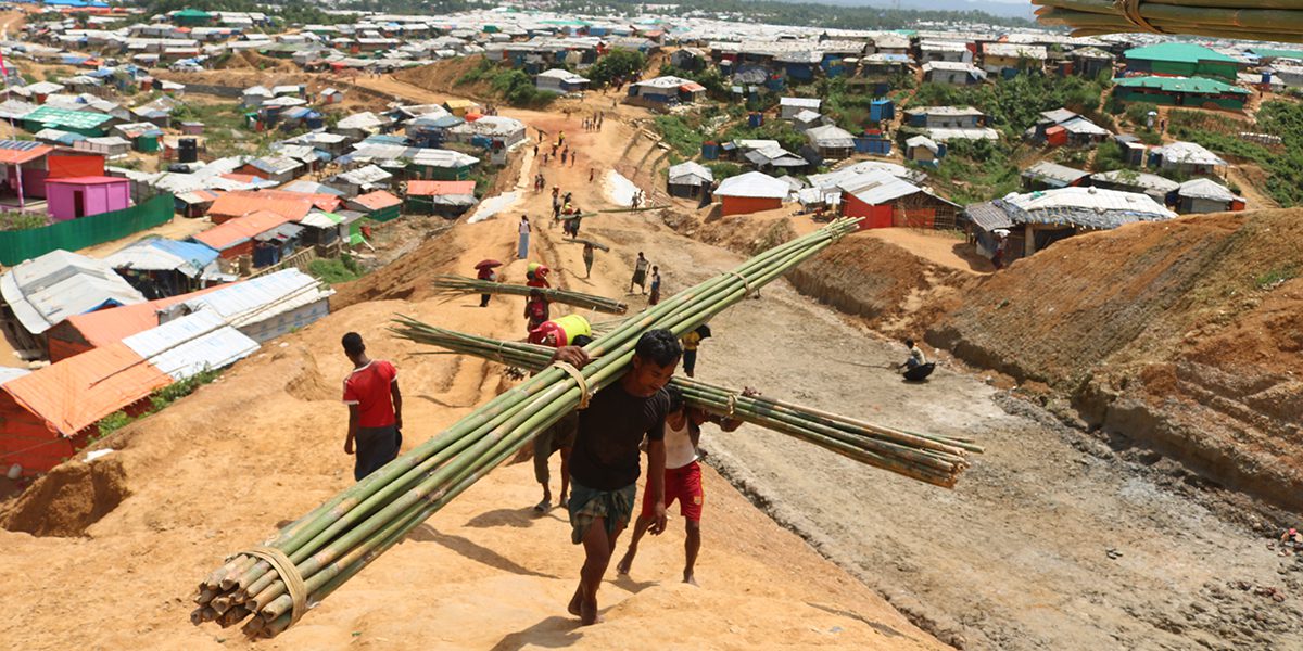 Hombres cargando bambú para la construcción de viviendas en Kutupalong, Cox's Bazar, JRS Bangladés.