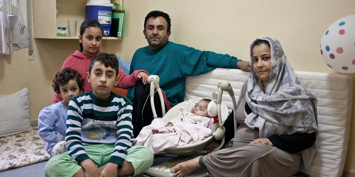 A family who found refuge at the JRS Greece shelter sits together