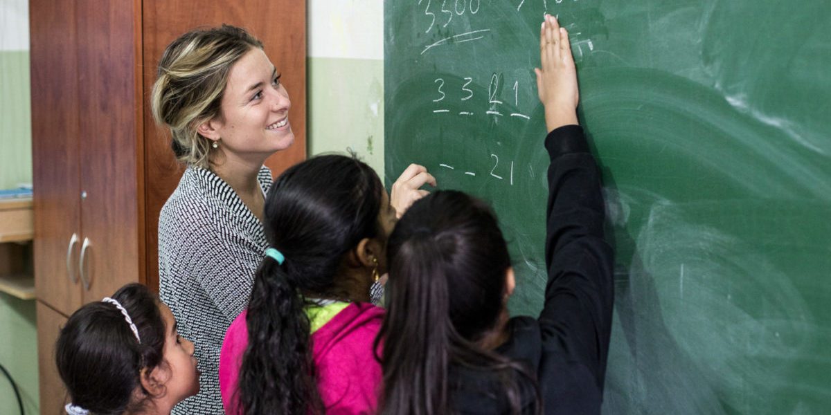 Una voluntaria hace de tutora en matemáticas e inglés para niñas y niños refugiados en el Centro Frans Van Der Lugt, Líbano. (Servicio Jesuita a Refugiados)