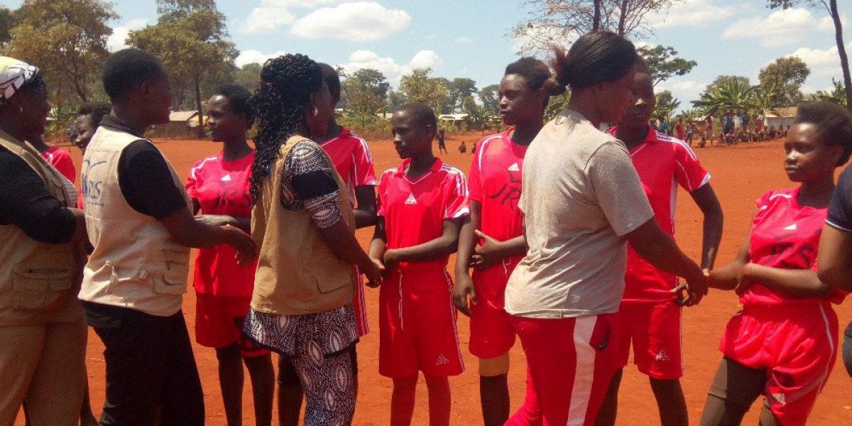 Le personnel de JRS et de Plan International saluent l’équipe féminine de football à l’occasion de la Journée mondiale de la jeunesse (JRS).