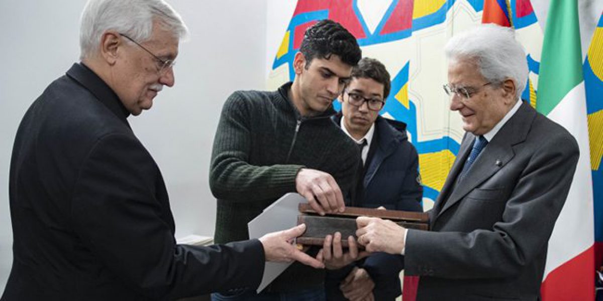 Mohammed, a refugee from Egypt, gives a present to the President of the Italian Republic for the inauguration of the new Matteo Ricci centre.