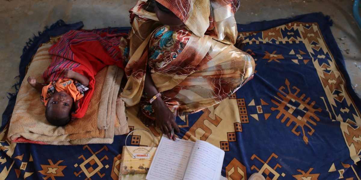 Noura studies with her baby beside her. (Sergi Camara)