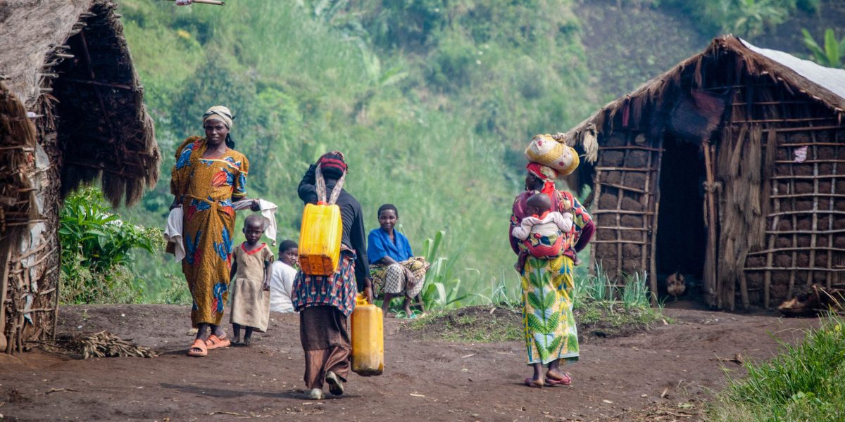 Mujeres y niños siguen con los quehaceres en sus hogares temporales en el campamento de desplazados internos de Muhanga, en el este de la República Democrática del Congo. (Servicio Jesuita a Refugiados)