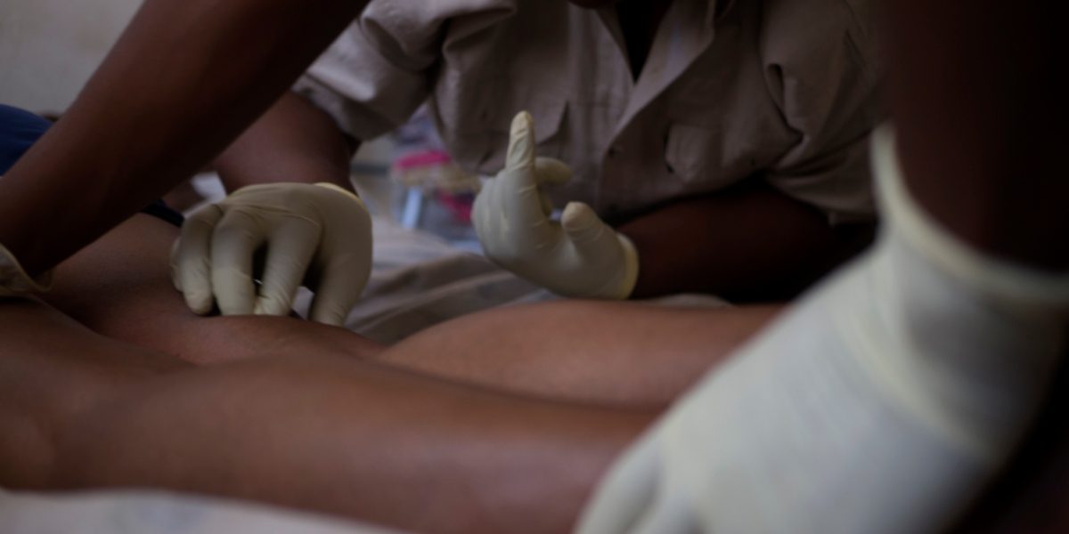 A member of JRS's health team attends to a patient in her home in Johannesburg. (Jesuit Refugee Service)