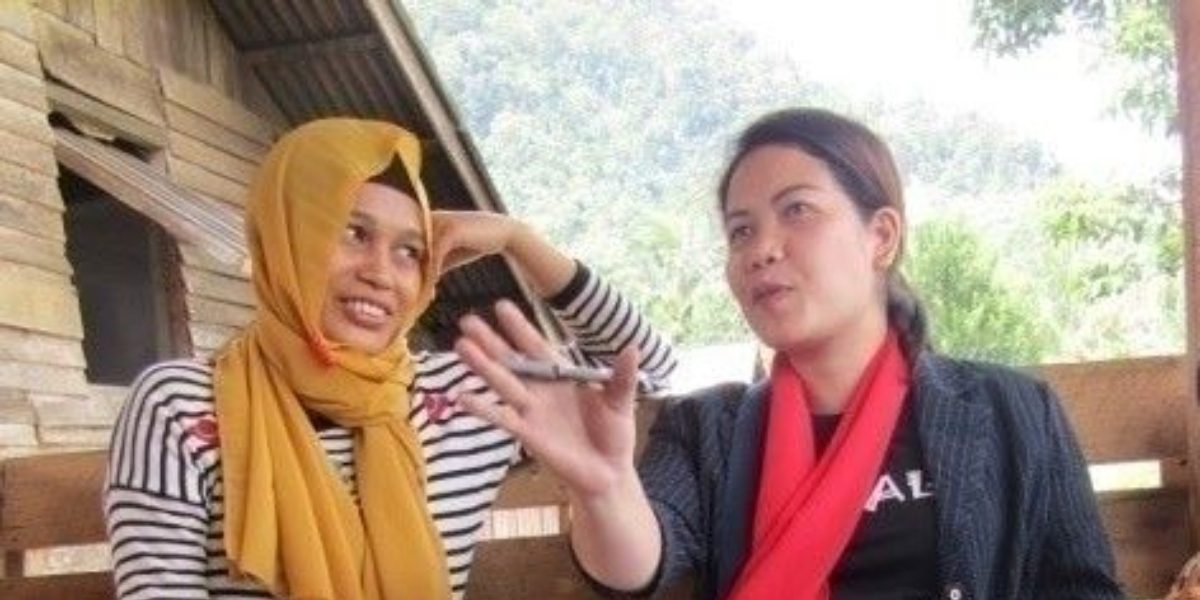 Le responsable de projet de JRS Philippines, Liezl B. Tingcang, et Normilah discutent du projet Women Advocating for Peace à Lanao del Norte. (JRS)