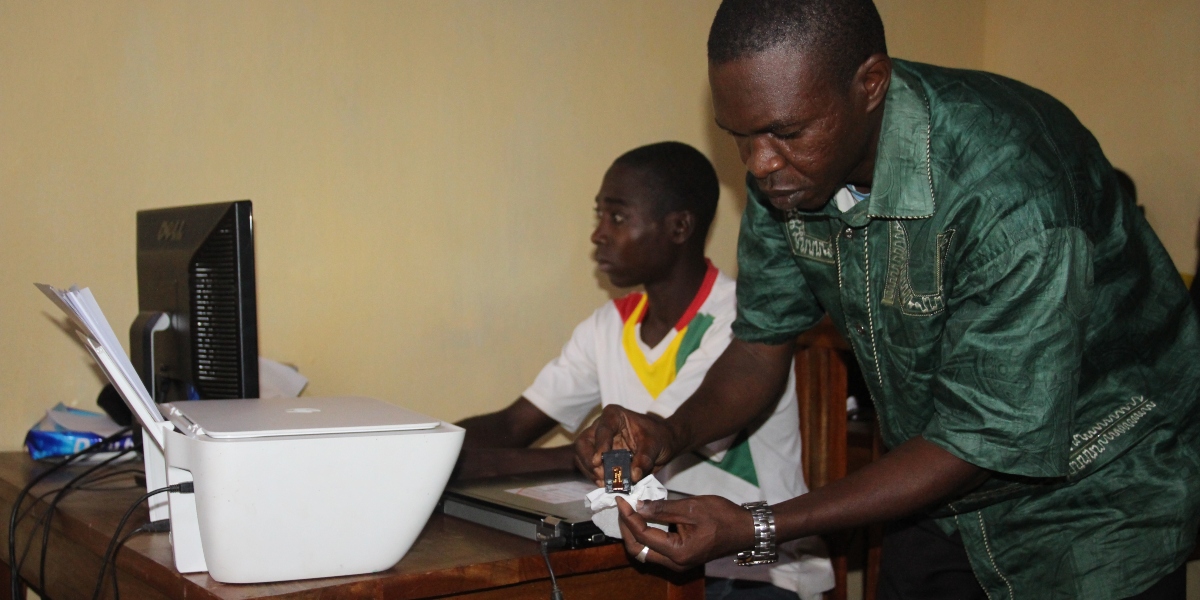 Jean Cadeau and Mahamat work hard to provide electronic services for their community. (Jesuit Refugee Service)