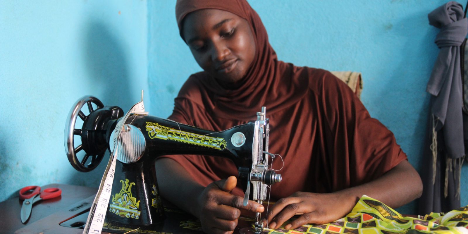 Una de las estudiantes del primer curso de costura, ofrecido por el JRS en Camerún, frente a su máquina de coser. Ella ya ha abierto su propia tienda con otras amigas del curso. (Servicio Jesuita a Refugiados)