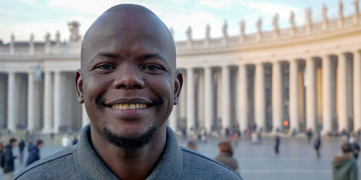 Taban Patrick Consantino SJ poses in front of St Peter's Square in the Vatican. A former JRS refugee student, Taban is now pursuing his vocation to become a Jesuit priest.
