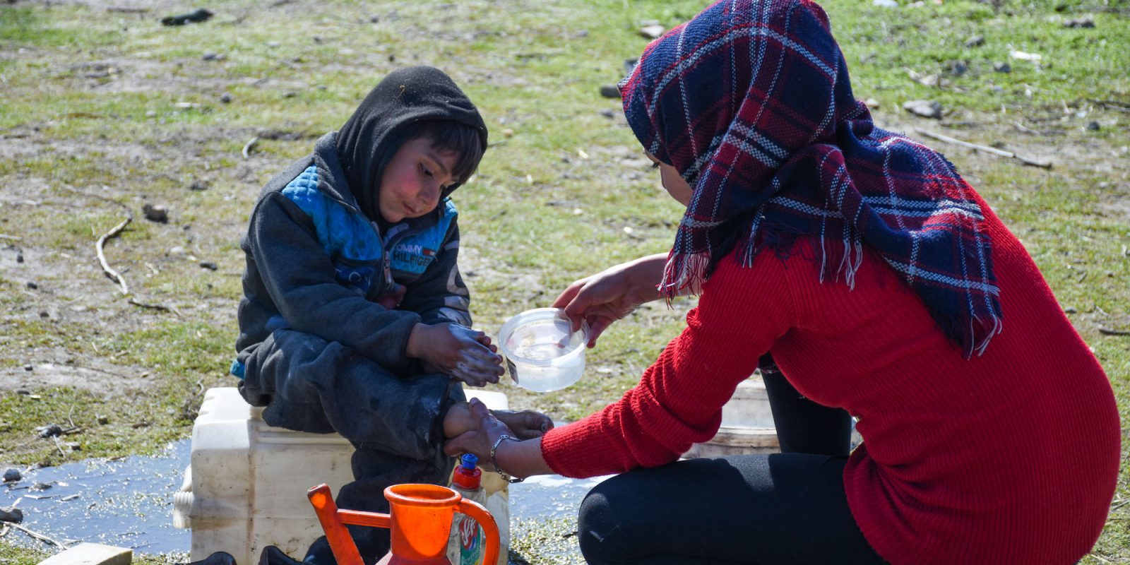 Una mujer lava los pies a un niño en un asentamiento de personas internamente desplazadas en Alepo tras el terremoto. P. Thomas H. Smolich SJ en su mensaje de Pascua, nos recuerda que simples gestos de acogida, escucha y el lavado de pies marcan la diferencia.