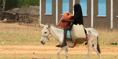Une fille transporte de l'eau dans le camp de réfugiés de Djabal, au Tchad. Le JRS Tchad, en réponse à la crise au Soudan, est intervenu en protégeant l'accès à l'éducation pour les réfugiés soudanais.