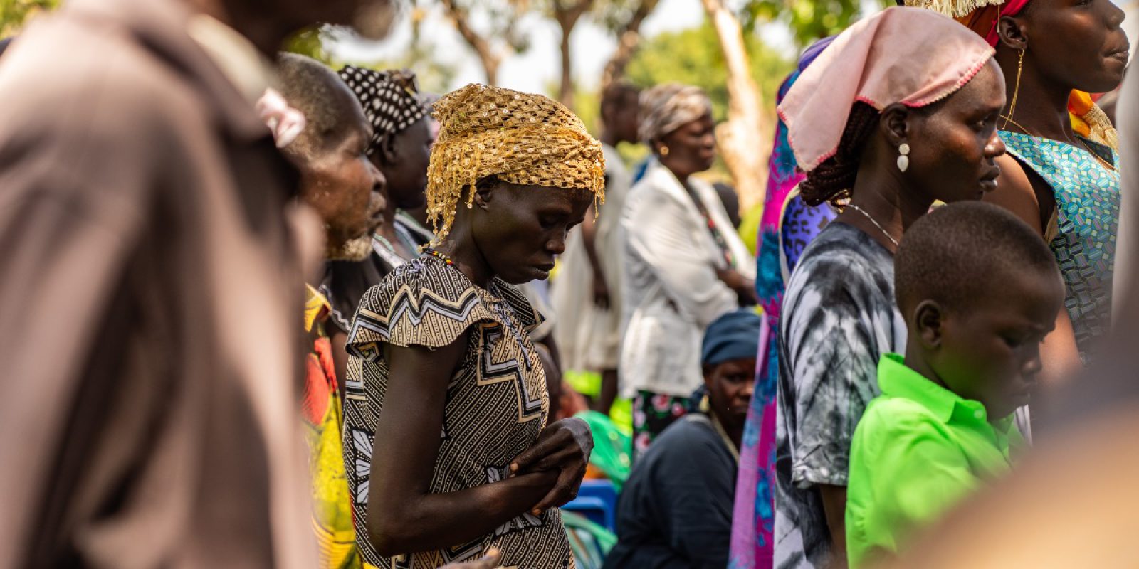 Cette année, les vœux de Pâques du JRS célèbrent l'esprit de résurrection des personnes que nous accompagnons. Une femme prie pendant une messe en Ouganda (Service jésuite des réfugiés).