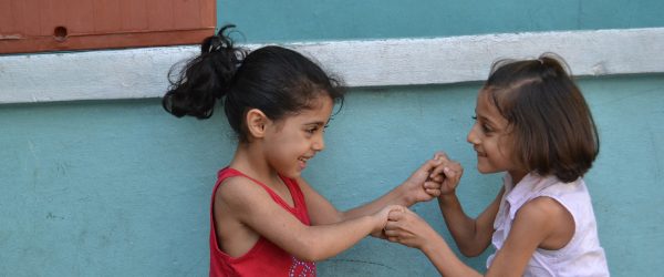 Two young refugees play in the school garden.