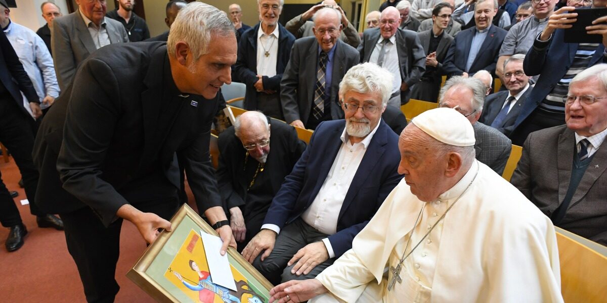 Fr Alberto Ares SJ, Regional Director of JRS Europe, offers Pope Francis a painting made by children hosted in one of JRS Ukraine’s shelters (Rev Antonio Spadaro SJ/La Civiltà Cattolica).