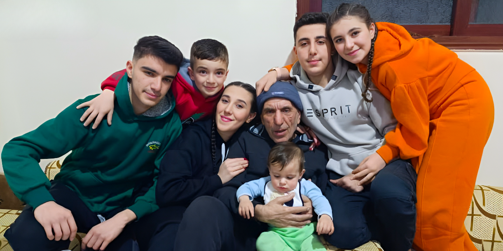 Nora is a Syrian woman who was just ten when her father was taken to prison. Becoming a volunteer with JRS helped her find her way. Nora's children with their grandfather (Jesuit Refugee Service).