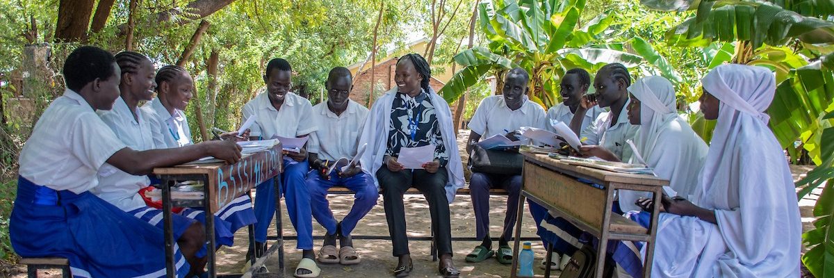 Los estudiantes del campamento de refugiados de Kakuma inspiran cambios promoviendo la sostenibilidad ambiental en sus comunidades. Los estudiantes miembros club medioambiental con su profesora, campamento de refugiados de Kakuma, Kenia (Servicio Jesuita a Refugiados).