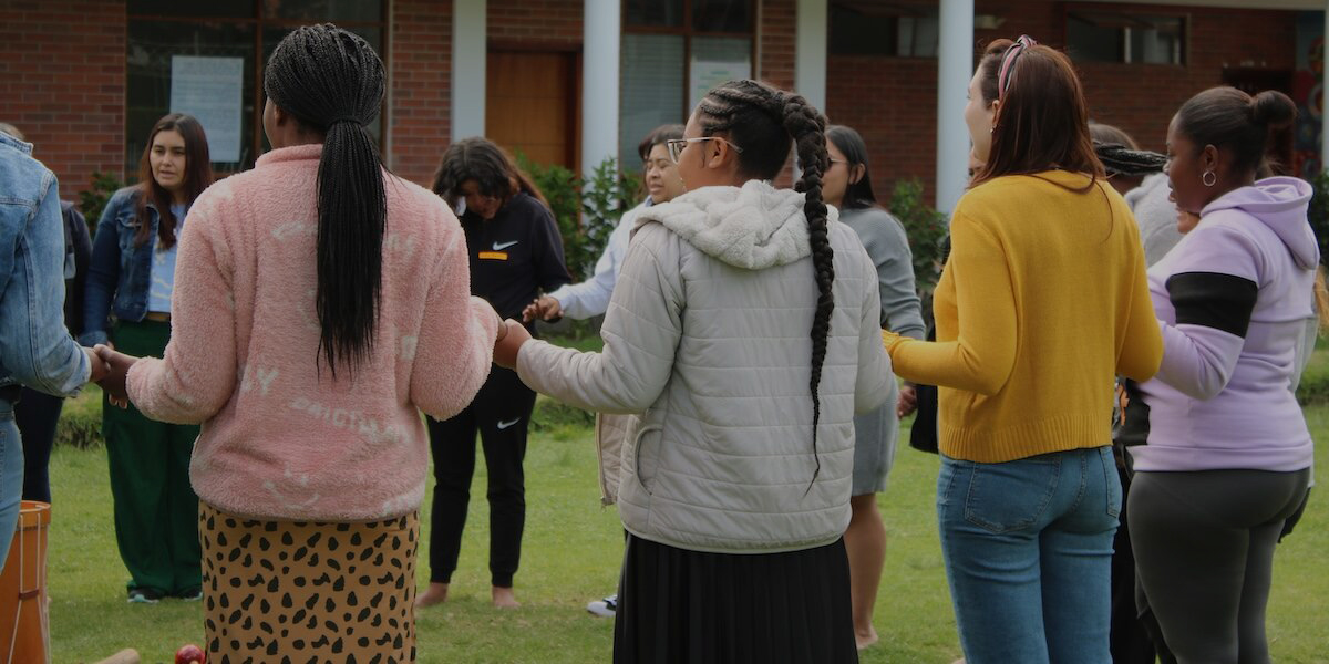 People holding hands at a reconciliation workshop in Ecuador